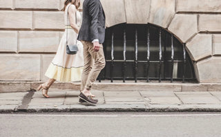 Well-dressed man and woman walking on city sidewalk in stylish casual clothing