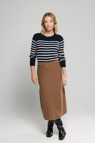 Woman wearing navy striped sweater and brown midi skirt with black boots