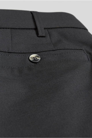 Close-up of black dress pants rear pocket with button and belt loop, men's fashion detail