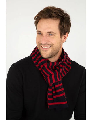 Man wearing red and navy striped wool scarf with black sweater, studio background