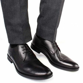 Men's black leather dress shoes with laces, paired with grey trousers
