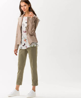 Woman wearing vintage cotton pants, light jacket, floral top and white sneakers