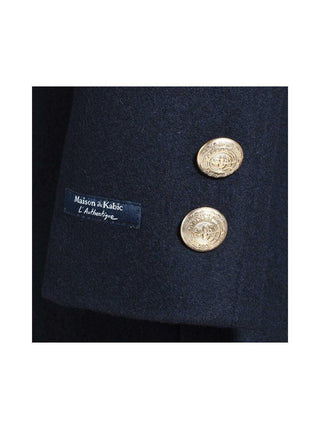 Close-up of navy wool coat sleeve with gold buttons and Maison du Kabic label for women