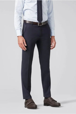 Men's slim fit navy wool dress pants styled with light blue shirt and brown loafers