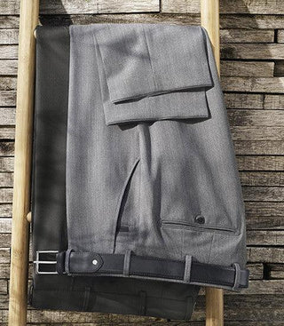 Light grey wool dress pants with belt draped on a wooden ladder, rustic wood background