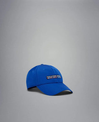 Blue nylon yachting cap with embroidered flag patch on front, isolated on grey background