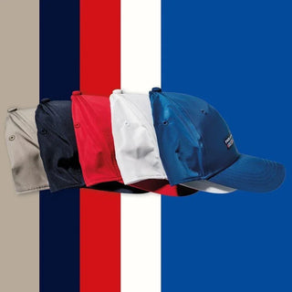 Five nylon yachting caps in beige, navy, red, white, and blue on striped background
