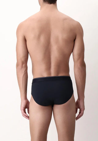 Male model wearing black briefs, back view, minimalist background, men's underwear
